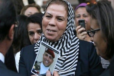 Latifa Ibn Ziaten shows a photograph of her son killed by Mohamed Merah, to France's President Francois Hollande