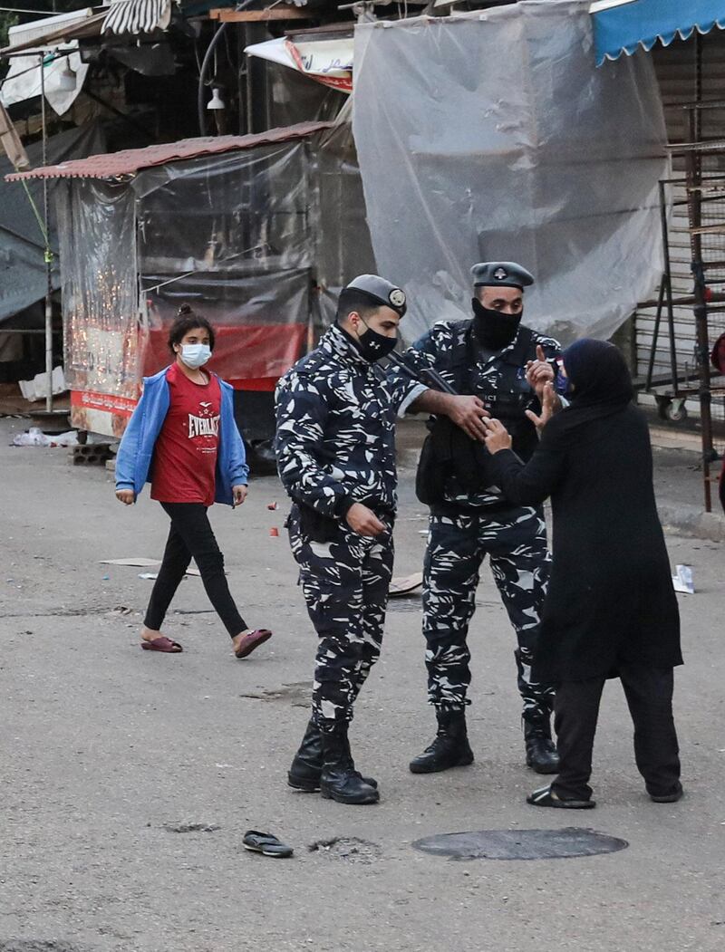 A woman argues with policemen trying to enforce a total lockdown as a measure against the COVID-19 coronavirus pandemic, in Souk Sabra in the southern suburbs of the Lebanon's capital Beirut.  AFP