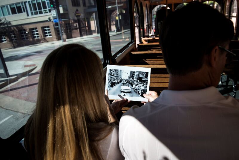 Tourists ride in a trolley along the JFK motorcade route in Dallas. AFP