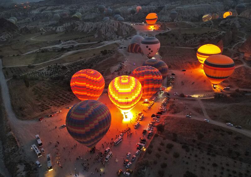 This aerial view shows hot air balloons launching in Goreme Historical National Park, east of Nevesehir (Neapolis) in the province of the same name in central Turkey's historical Cappadocia (Kapadokya) region on August 24, 2022.  (Photo by Omar HAJ KADOUR  /  AFP)