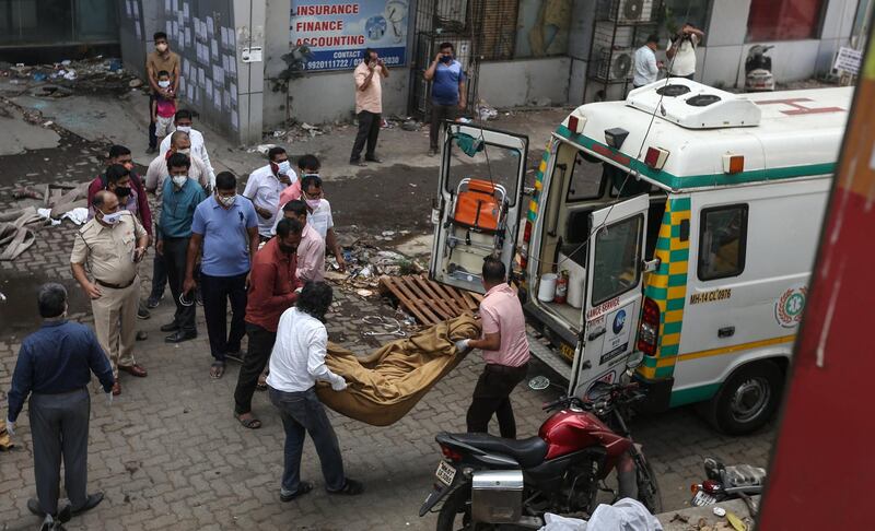 People load a body onto an ambulance in the aftermath of a fire that broke out at a Covid-19 hospital inside a mall in Mumbai. EPA