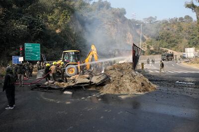 Indian security forces douse a burning lorry, which troops intercepted after its 'unusual movement' on a motorway. AP


