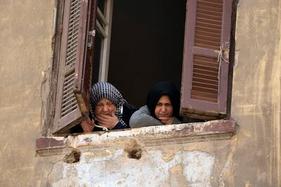 Women peer from their apartment window in the old quarter of the Egyptian capital, Cairo, Egypt. AP
