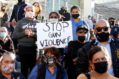 A girl holds a sign as people attend a vigil for the victims of a shooting at San Jose City Hall in San Jose, California, on May 27, 2021. A public transit worker shot dead eight people, including Rudometkin, at a California rail yard on May 26 before turning his gun on himself as police arrived, officials said after the latest mass shooting to hit the United States. / AFP / Amy Osborne
