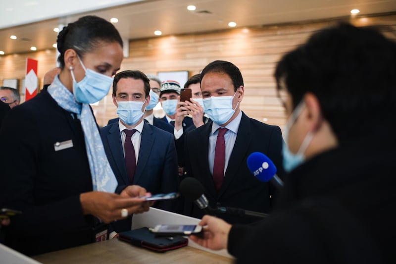 Jean-Baptiste Djebbari, France's transport minister, second left, and Cedric O., France's digital affairs minister, second right, watch Air France-KLM check-in staff demonstrating the 'TousAntiCovid' Coronavirus smartphone tracing app at Orly Airport in Paris, France, on Tuesday, April 27, 2021. France is moving toward a broad rollout of digital health certificates, putting the country at the forefront of a European Union push for vaccine passports to jumpstart travel. Photographer: Nathan Laine/Bloomberg
