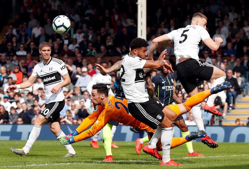 Fulham goalkeeper Sergio Rico, center, falls down after punching the ball clear. AP Photo