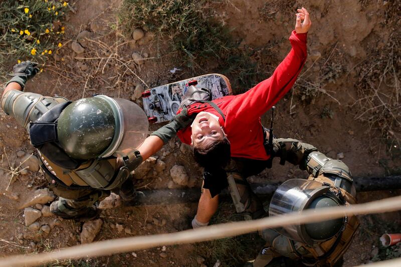 A demonstrator is detained by riot police during clashes which erupted in a protest against Chile's President Sebastian Pinera.  AFP
