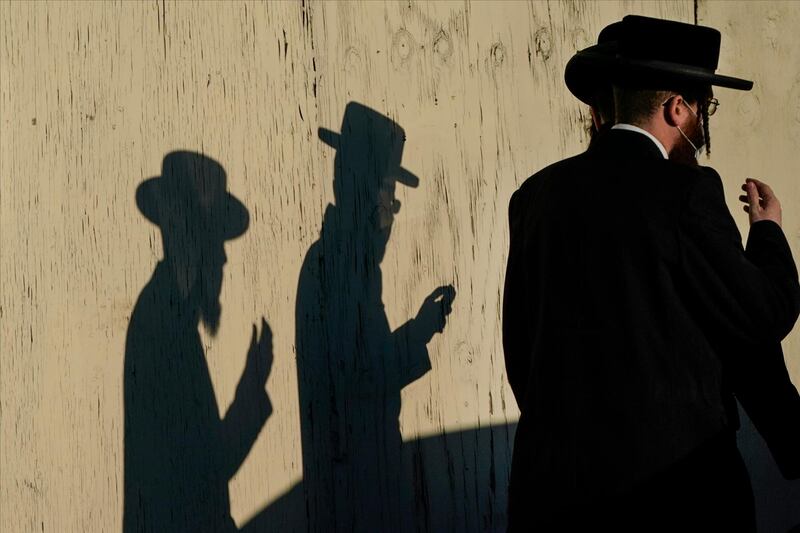 Men walk past the Yetev Lev temple in the Brooklyn borough of New York. Compliance with coronavirus restrictions in some of New York's Orthodox Jewish communities has been an issue since the pandemic started last spring. AP Photo