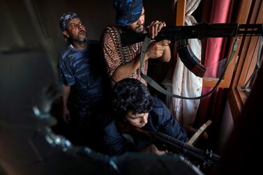 Fighters of the Shelba unit, allied with the Government of National Accord, take aim in the Salahaddin neighbourhood in Tripoli on Saturday. AP