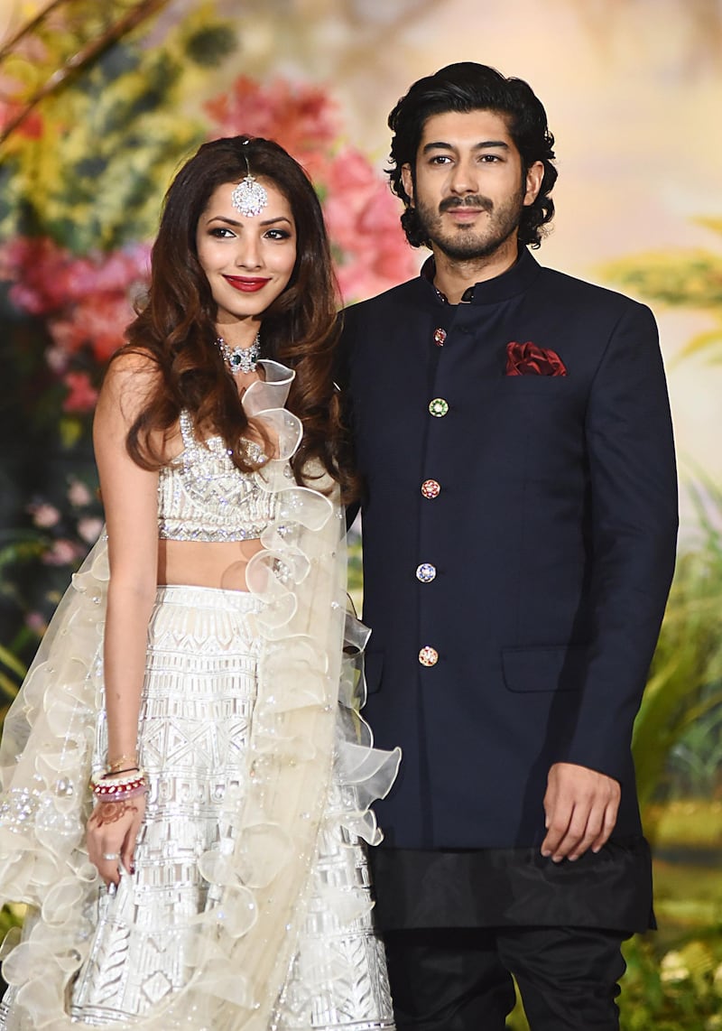 Actor Mohit Marwah with his wife Antara Motiwala - who recently wed in Ras Al Khaimah -  pose for a picture during the wedding reception of actress Sonam Kapoor and businessman Anand Ahuja in Mumbai late on May 8, 2018. AFP PHOTO / Sujit Jaiswal