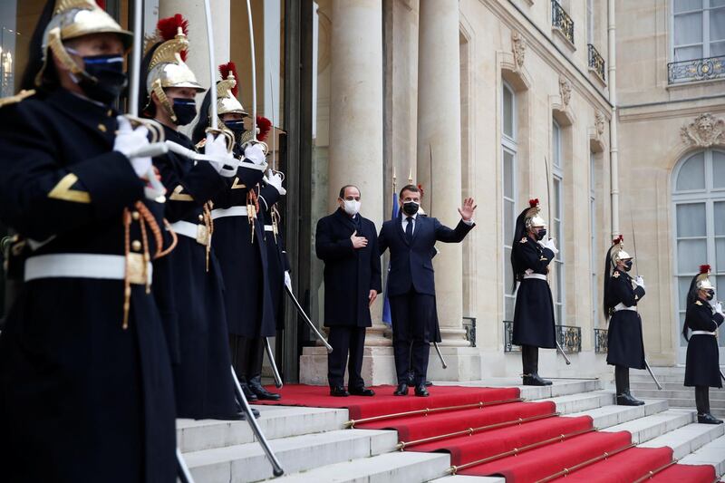 French President Emmanuel Macron waves from the steps of the Elysee Palace with Egyptian President Abdel Fattah El Sisi. Reuters