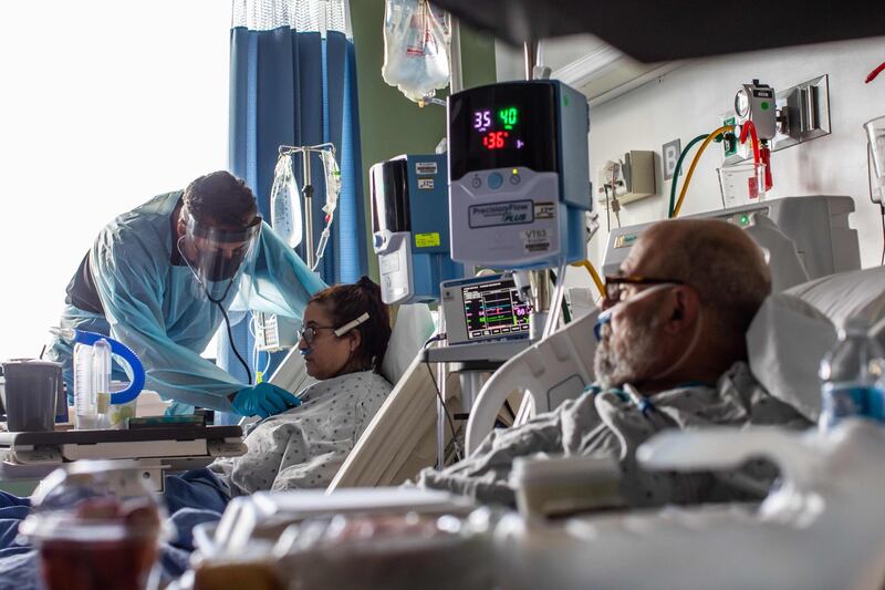 Medical Director of the Intensive Care Unit, Dr. Thomas Yadegar, checks the vital signs of Mindy Cross while her husband Dr. Neil Hecht (R) rests in a bed next to her at Providence Cedars-Sinai Tarzana Medical Center in Tarzana, California. Apu Gomes / AFP