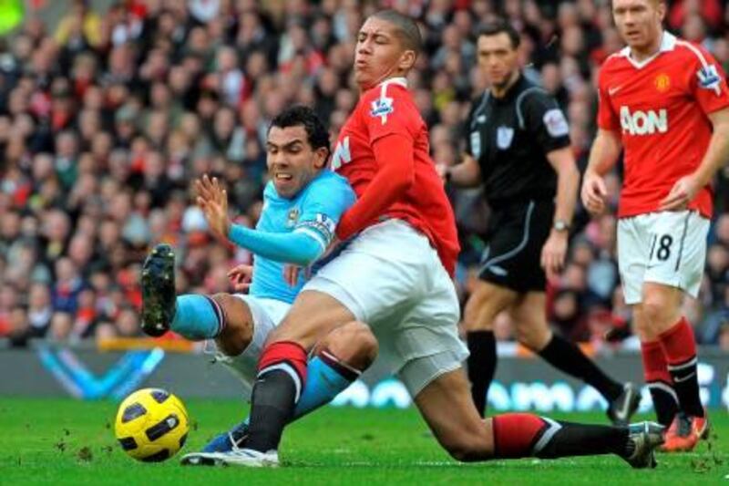 Manchester City's Argentinian striker Carlos Tevez (L) vies with Manchester United's English defender Chris Smalling (2nd L) during the English Premier League football match between Manchester United and Manchester City at Old Trafford in Manchester, north-west England on February 12, 2011. AFP PHOTO/ANDREW YATES

RESTRICTED TO EDITORIAL USE Additional licence required for any commercial/promotional use or use on TV or internet (except identical online version of newspaper) of Premier League/Football League photos. Tel DataCo +44 207 2981656. Do not alter/modify photo