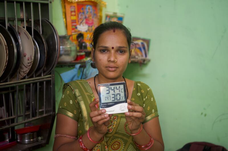 A resident of Indiranagar shows the temperature inside her home, which is yet to be painted