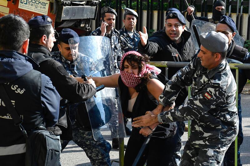 An activist clashes with Lebanese riot police during a protest to demand the opening of the Rafah border crossing, outside the Egyptian embassy in Beirut. EPA