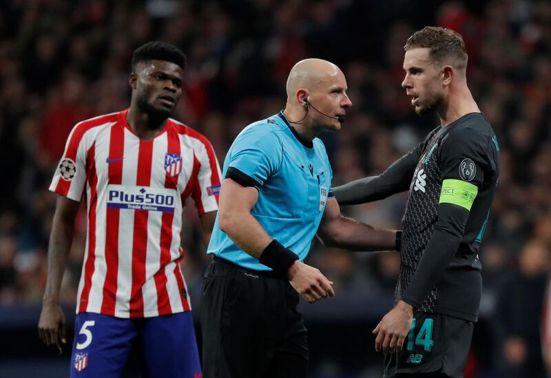 Liverpool's Jordan Henderson speaks to referee Szymon Marciniak. Reuters