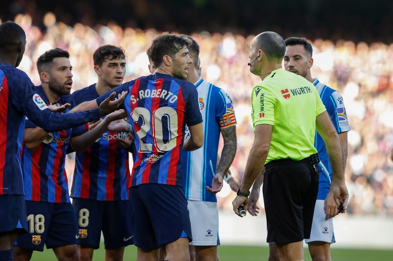 Barcelona defender Jordi Alba, left, argues with the referee after being shown a second yellow card against Espanyol. EPA