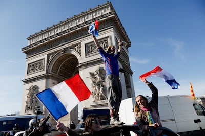 A protester stands atop a vehicle as cars parade around the Arc de Triomphe during the 'Freedom Convoy' demonstration on Saturday. 
Photo: REUTERS/Benoit Tessier
