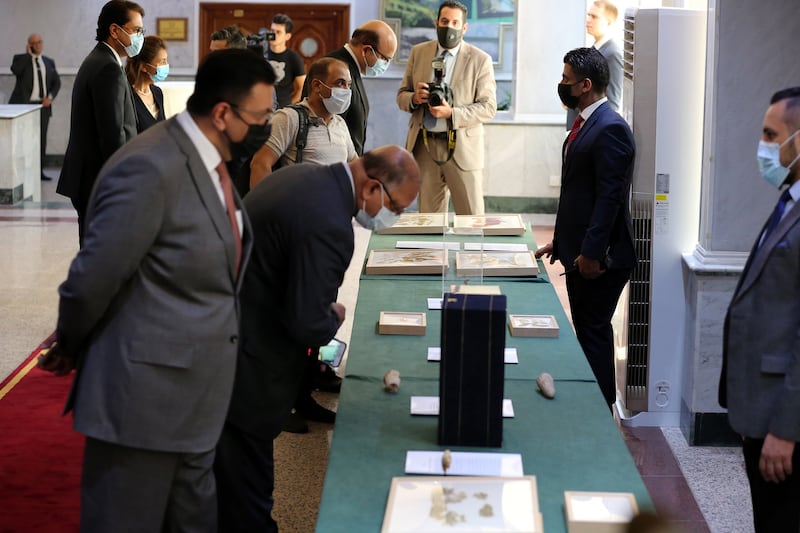 Members of Arab and foreign diplomatic missions inspect the returned artefacts at the Iraqi  Ministry of Foreign Affairs in Baghdad.