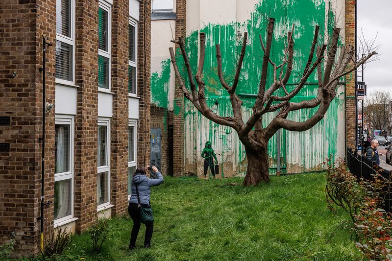 People take pictures of a new Banksy artwork in Islington, London, in March 2024. Getty Images