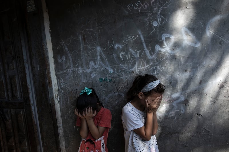 Young Palestinian girls are overcome at the funeral of 11-year-old Layan al-Shaer in Khan Younis, the Gaza Strip. She was killed by an Israeli air strike. AP Photo