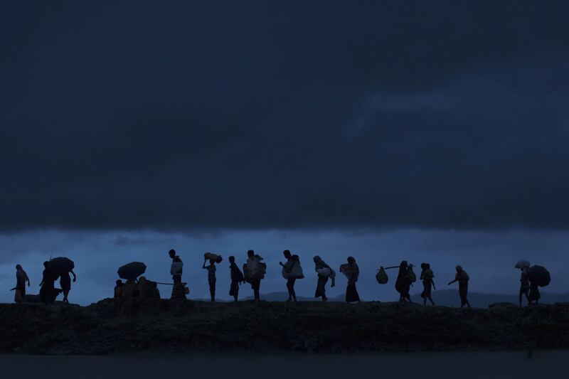 GUNDUM, BANGLADESH - SEPTEMBER 09:  Rohingya refugees walk across Paddy fields at dusk after crossing the border from Myanmar on September 09, 2017 in Gundum, Bangladesh. Recent reports have suggested that around 290,000 Rohingya have now fled Myanmar. Those who left have spoken of violence erupting in Rakhine state, when the country's security forces allegedly launched an operation against the Rohingya Muslim community.  (Photo by Dan Kitwood/Getty Images)