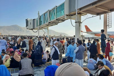 Afghans crowd the tarmac of the Kabul airport on August 16, 2021. AFP