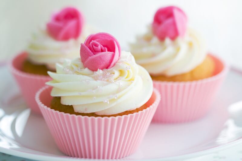 Cupcakes decorated with frosting and pink wafer roses