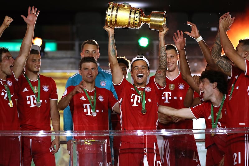 Philippe Coutinho holds the German Cup trophy aloft. EPA