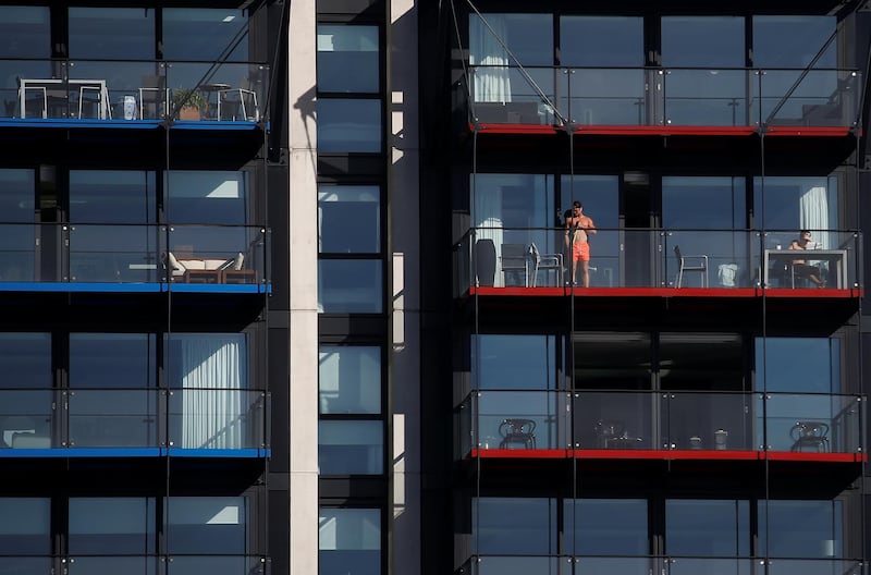 People sunbathing on their balconies , as the spread of the coronavirus continues, in London, UK on April 5, 2020. Reuters