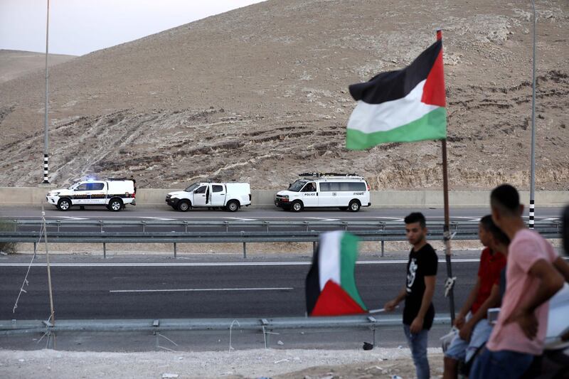 epa07027535 Palestinians hold the Palestinian flag near the Bedouin village of Khan al-Ahmar, located between the West Bank city of Jericho and Jerusalem near the Israeli settlement of Maale Adumim, 17 September 2018. Khan al-Ahmar is a Bedouin community where some 180 people live in shacks, which Israeli authorities claim were built without obtaining permits. Israeli authorities plan to demolish the shacks after the Israeli High Court of Justice rejected petitions filed by Khan al-Ahmar residents against their evacuation.  EPA/ABED AL HASHLAMOUN