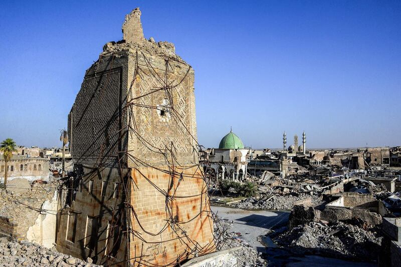 TOPSHOT - A picture taken on July 9, 2018 shows a view of the base of the destroyed "Al-Hadba" leaning minaret, with the dome of the destroyed Al-Nuri Mosque seen behind in the Old City of Mosul, a year after the city was retaken by the Iraqi government forces. Iraqi forces announced the "liberation" of the country's second city on July 10, 2017, after a bloody nine-month offencive to end the Islamic State (IS) group's three-year rule there. Scores of people are still displaced in and around Mosul as the city lies in ruins, one year after it was retaken from IS.  / AFP / Zaid AL-OBEIDI
