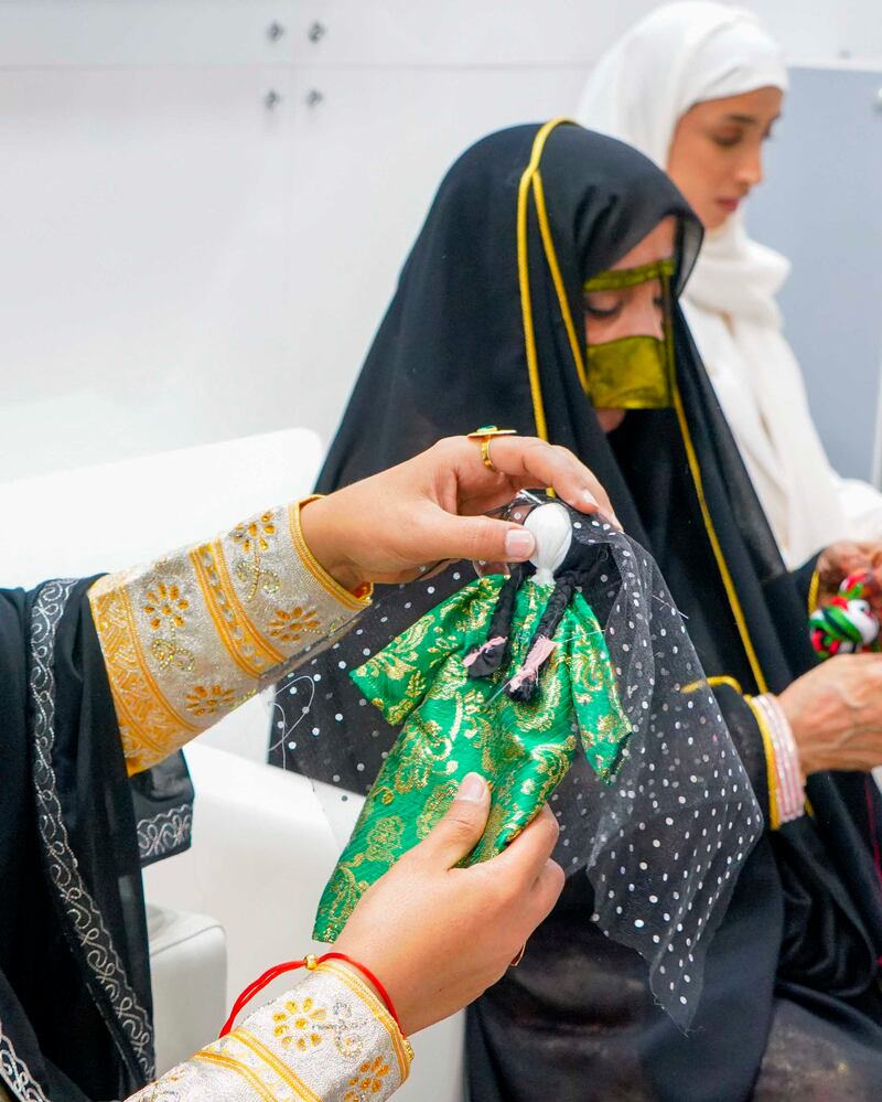 The women showcase various aspects of Emirati arts and crafts, from clothing to fragrance