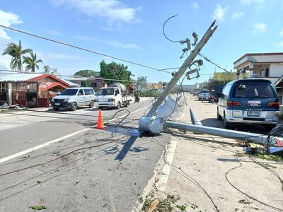 epa08090595 Vehicles maneuver next to a toppled electric post in the typhoon-hit town of Balasan, Ilo-Ilo province, Philippines, 26 December 2019. According to media reports, Typhoon Phanfone, locally known as Ursula, lashed the central Philippines on Christmas Day killing at least 16 people and causing damage to homes and rice fields.  EPA/LEO SOLINAP