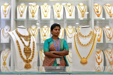 A saleswoman stands next to gold necklaces at a jewellery store in Bangalore. Photo: AFP