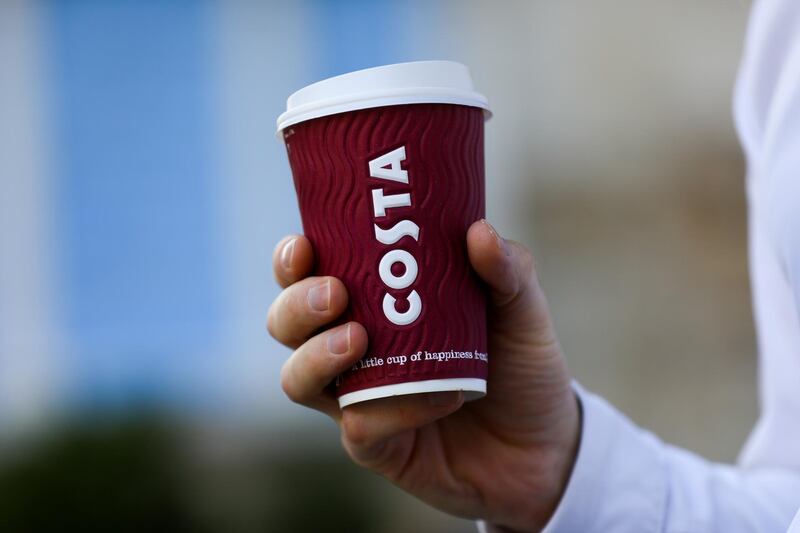 A customer holds a branded Costa Coffee cup in this arranged photo outside a Costa Costa coffee shop in London, U.K., on Friday, Aug. 31, 2018. Coca-Cola Co. agreed to buy the U.K. chain Costa Coffee for 3.9 billion pounds ($5.1 billion), stepping into a battle with Nestle SA and Starbucks Corp. as it gains a global brand in hot drinks. Photographer: Simon Dawson/Bloomberg