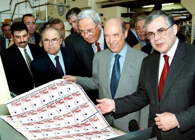 The Greek Prime Minister Costas Simitis, second right, with euro banknotes on a visit to the Greek national mint in Athens on October 31, 2001. EPA