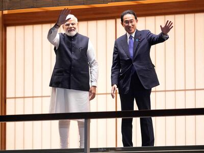 Indian Prime Minister Narendra Modi and Japanese Prime Minister Fumio Kishida wave after feeding carp before their dinner at Akasaka State Guest House in Tokyo. AFP