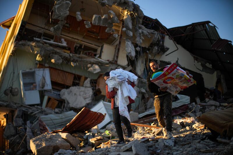 Residentes remove their belongings from their destroyed house in Samandag. AP