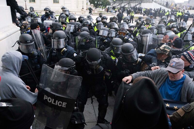 FILE - In this Jan. 6, 2021, file photo, U.S. Capitol Police push back rioters trying to enter the U.S. Capitol in Washington. A former State Department aide in President Donald Trumpâ€™s administration has been charged with participating in the deadly siege at the Capitol. Court papers say Federico Klein was seen wearing a â€œMake America Great Again" hat amid the throng of people trying to force their way into the Capitol. Authorities say Klein pushed his way toward the doors, where â€œhe physically and verbally engagedâ€ with officers trying to keep the mob back. Klein resigned from his position on Jan. 19, the day before Joe Biden was sworn in as president. (AP Photo/Jose Luis Magana, File)