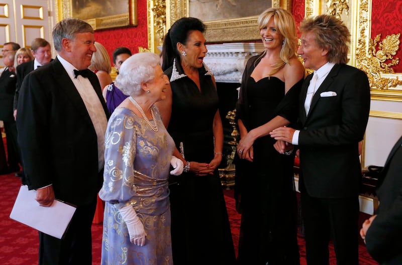 Queen Elizabeth greets Penny Lancaster and pop star Rod Stewart at St James's Palace in 2013. Getty Images