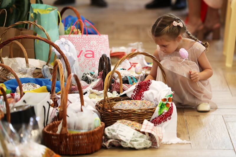 A Ukrainian girl places an Easter egg in a basket during the Easter Mass held at St Joseph's Cathedral in Abu Dhabi. All photos: Pawan Singh / The National