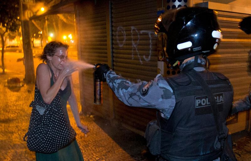 A military police peper sprays a protester during a demonstration in Rio de Janeiro, Brazil, Monday, June 17, 2013. Protesters massed in at least seven Brazilian cities Monday for another round of demonstrations voicing disgruntlement about life in the country, raising questions about security during big events like the current Confederations Cup and a papal visit next month. ((AP Photo/Victor R. Caivano) *** Local Caption ***  Brazil Confed Cup Protests.JPEG-060ba.jpg