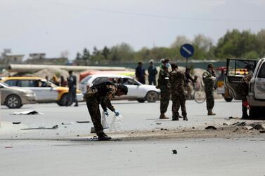 Afghan security forces inspect the site of a bomb explosion near a damaged vehicle in Kabul, Afghanistan, Monday, April 27, 2020. AP