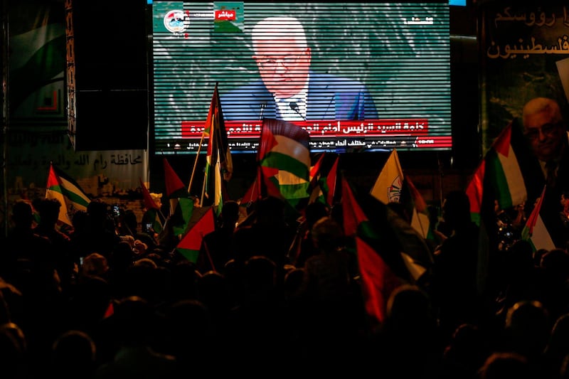 Palestinians watch Palestinian president Mahmoud Abbas on a large screen in the West Bank city of Ramallah. AFP