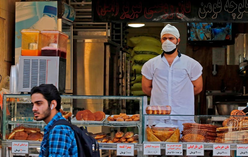 An Iranian man walks in front of a pastry shop in the capital Tehran.  AFP