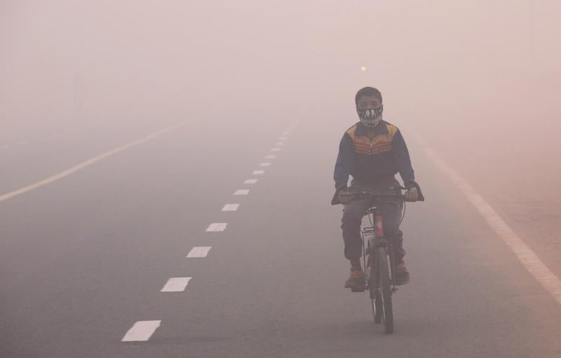 An Indian boy wearing a face mask cycles in smog, one day after the Diwali festival, in New Delhi, India, on October 31, 2016. According to a news report, hundreds of people faced breathing problem and poor visibility due to heavy smog after fireworks set off during the Diwali festival in Delhi have worsened the pollution problem. Rajat Gupta/EPA