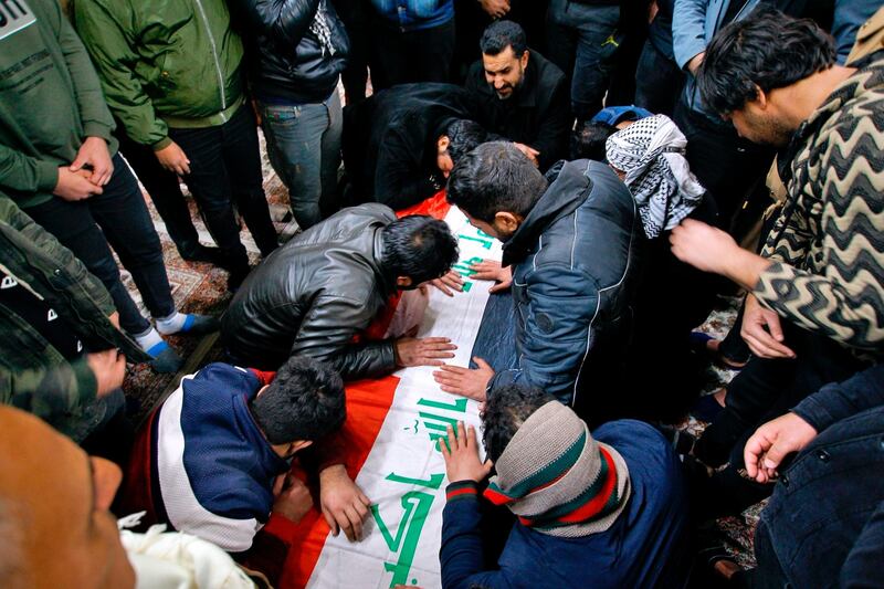 Mourners mourn by the flag-draped coffin of a suicide bomb victim, Samer Hassan, during his funeral procession at the Imam Ali shrine in Najaf, Iraq.  AP