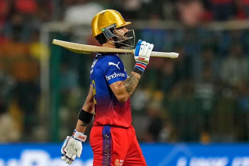 Royal Challengers Bengaluru's Virat Kohli walks off the field after losing his wicket, caught by Harpreet Brar off the bowling of Harshal Patel. AP 