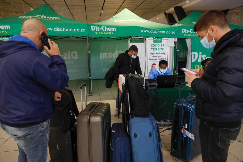 A healthcare worker helps a traveller to obtain his PCR test result at OR Tambo International Airport in Johannesburg, after several countries banned flights from South Africa following the discovery of a new coronavirus variant called Omicron. AFP